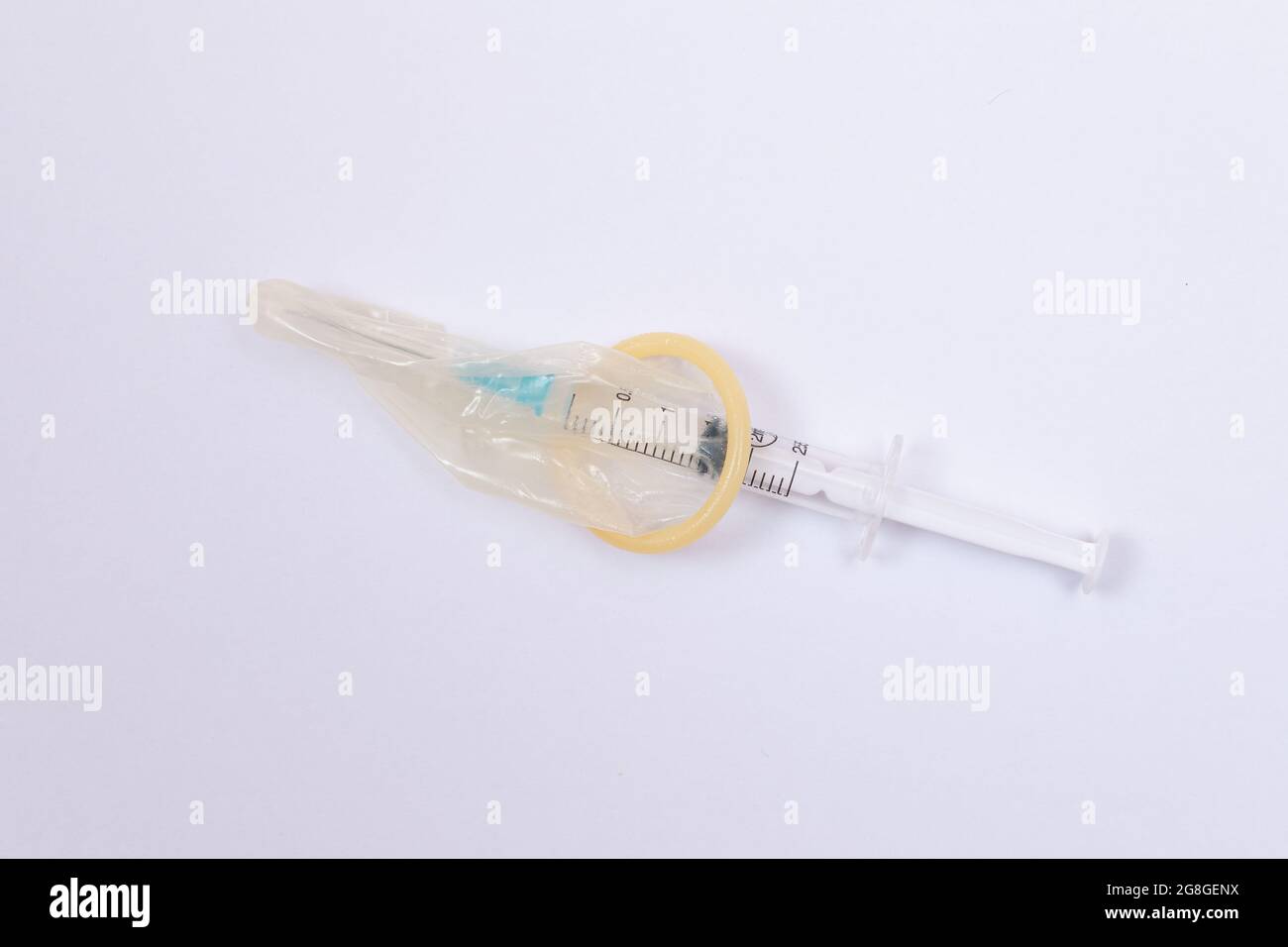 Concept de vaccin sûr et anti-vaccination - seringue dans un condom sur une table blanche. Méfiance à l'égard de la vaccination. Immunité naturelle. Scepticisme à propos du vaccin. Liberté et droits de l'homme Banque D'Images