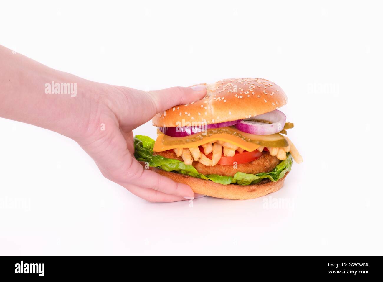 Faire un gros hamburger de poulet avec du fromage et des légumes à la main Banque D'Images