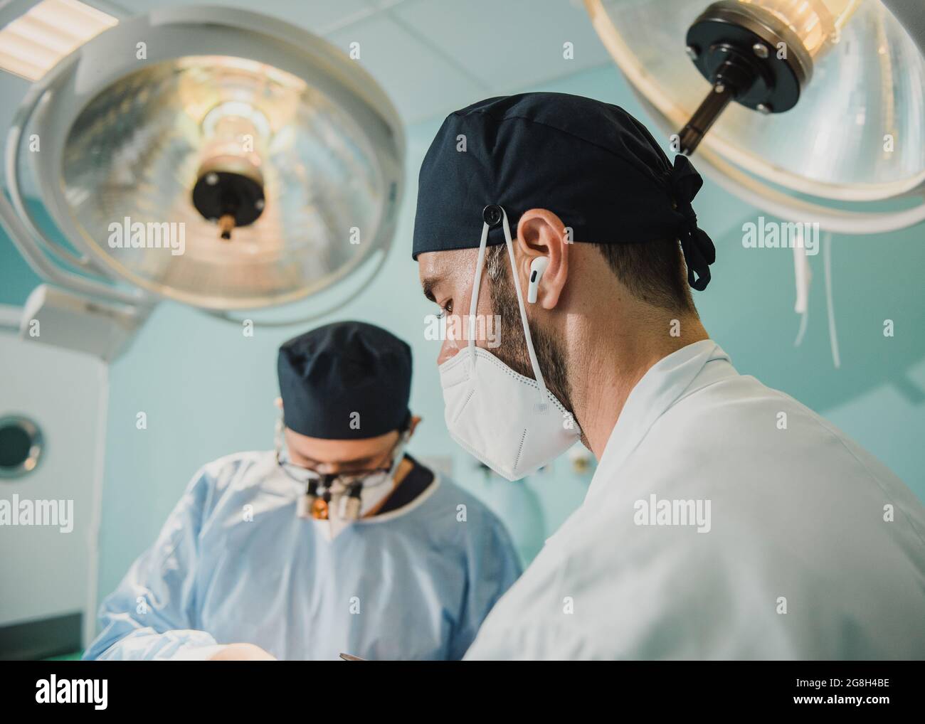 Médecins travaillant dans la salle d'opération de la clinique de l'hôpital - Focus sur le visage masculin droit Banque D'Images