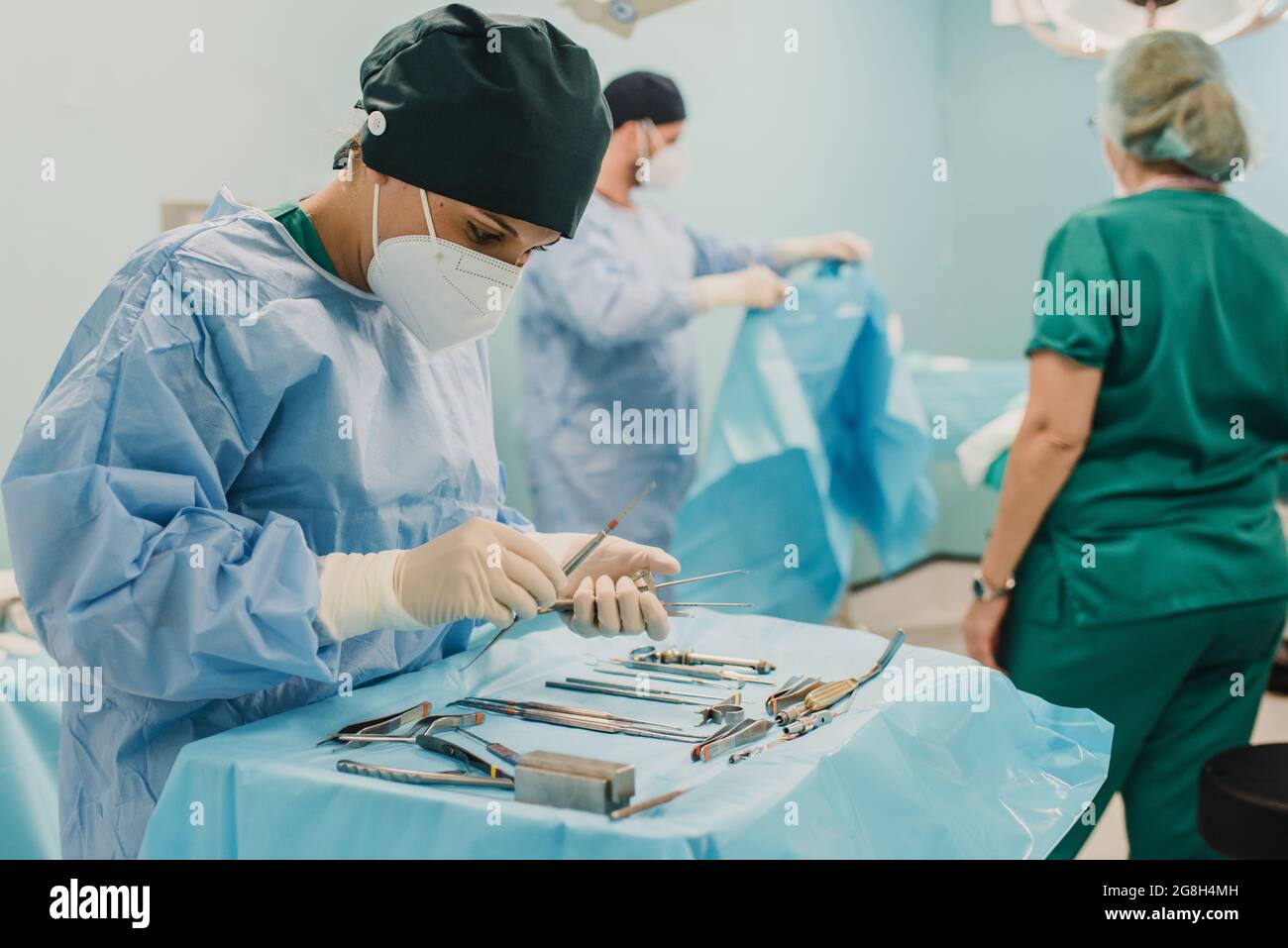 Infirmière féminine préparant l'équipement chirurgical pour l'opération à l'intérieur de la clinique d'urgence de l'hôpital - Focus sur le visage Banque D'Images