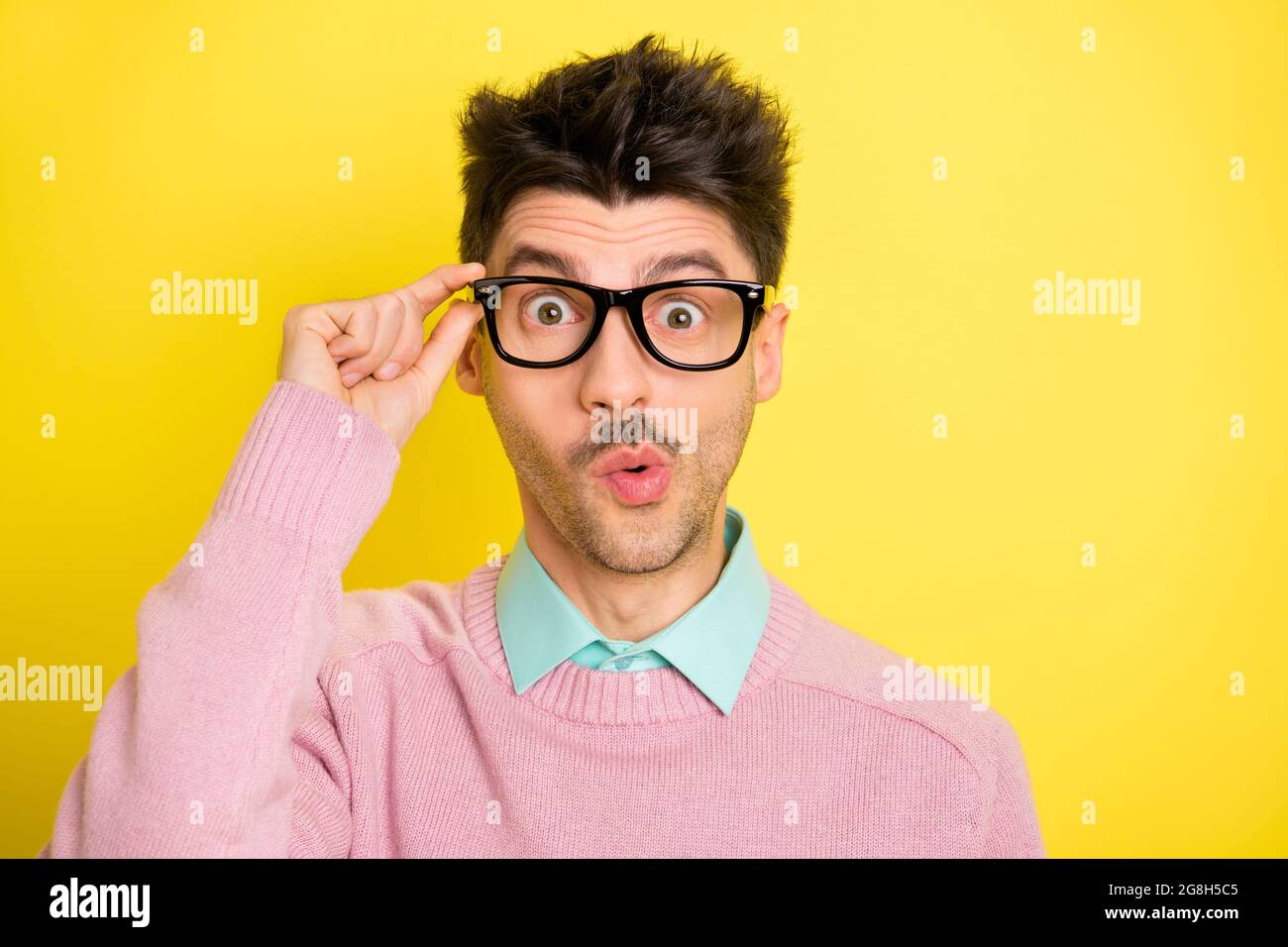 Photo de jeune beau sérieux choqué surpris surpris homme dans des verres funky isolé sur fond jaune Banque D'Images