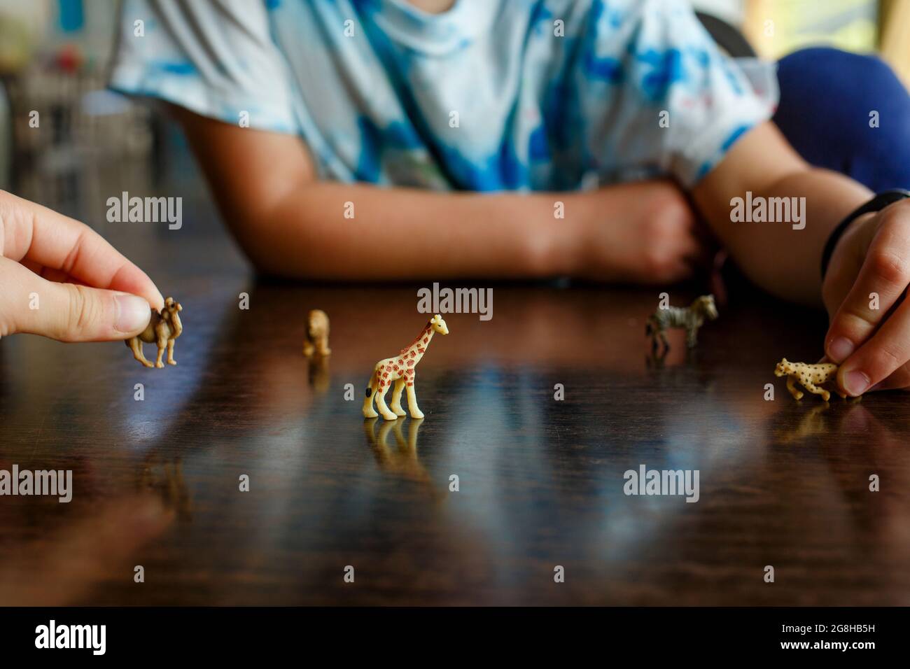 deux enfants jouent avec des animaux miniatures sur la table Banque D'Images