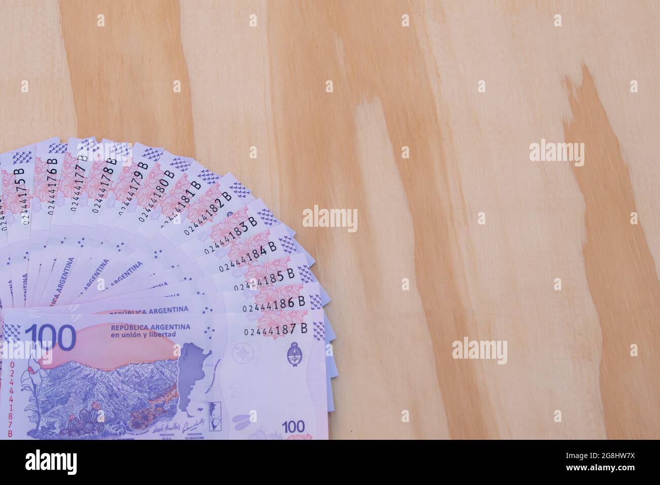 Billets argentins de 100 pesos, taruca, de numérotation corrélative. Avec un fond en bois. Banque D'Images