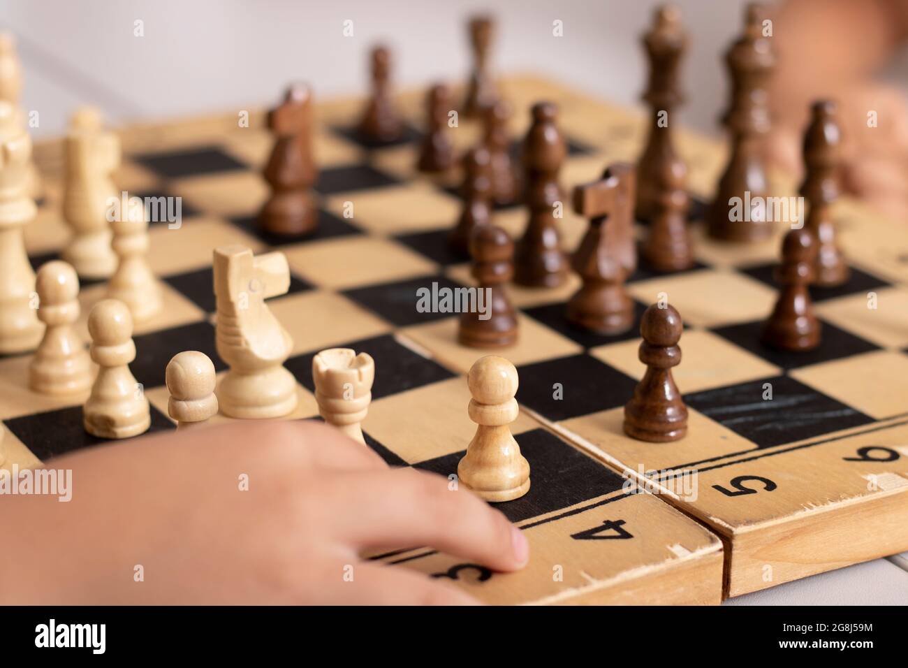 Boy hildong rook en bois, frères et sœurs jouant aux échecs à la maison Banque D'Images