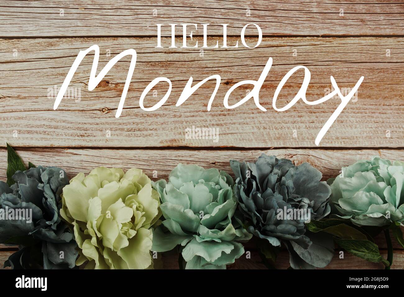 Bonjour lundi texte typographique avec bouquet de fleurs bleues sur fond en bois Banque D'Images