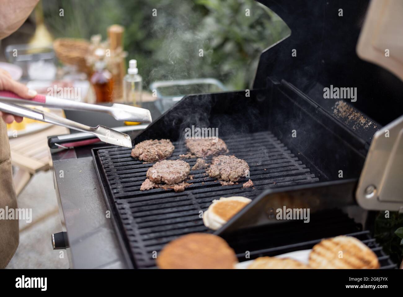 Griller des hamburgers sur un gril à l'extérieur Banque D'Images