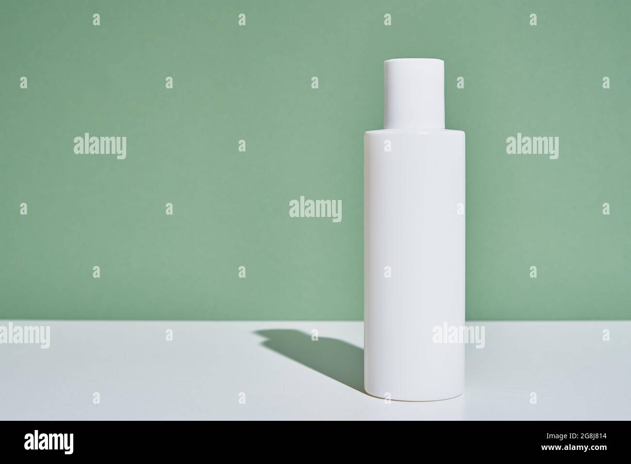 Maquette de cosmétiques naturels. Concept de produit de beauté. Bouteille blanche sur fond vert Banque D'Images