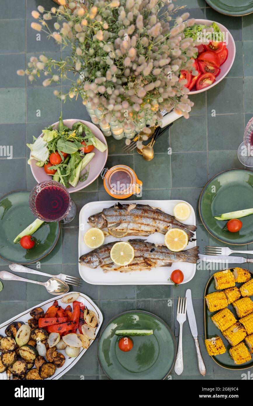 Table avec des légumes et du poisson grillés Banque D'Images