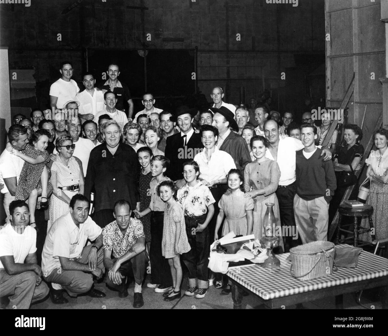 Casting et équipe sur la pose en chandide, y compris le cinéaste STANLEY CORTEZ (2e gauche à genoux) Directeur CHARLES LAUGHTON LILLIAN GISH ROBERT MITCHUM et BILLY CHAPIN pendant le tournage de LA NUIT DE LA HUNTER 1955 réalisateur CHARLES LAUGHTON roman Davis Grubb scénario James Agate cinéaste Stanley Cortez musique Walter Schumann direction artistique Hiliard M. Brown Paul Gregory Productions / United Artists Banque D'Images