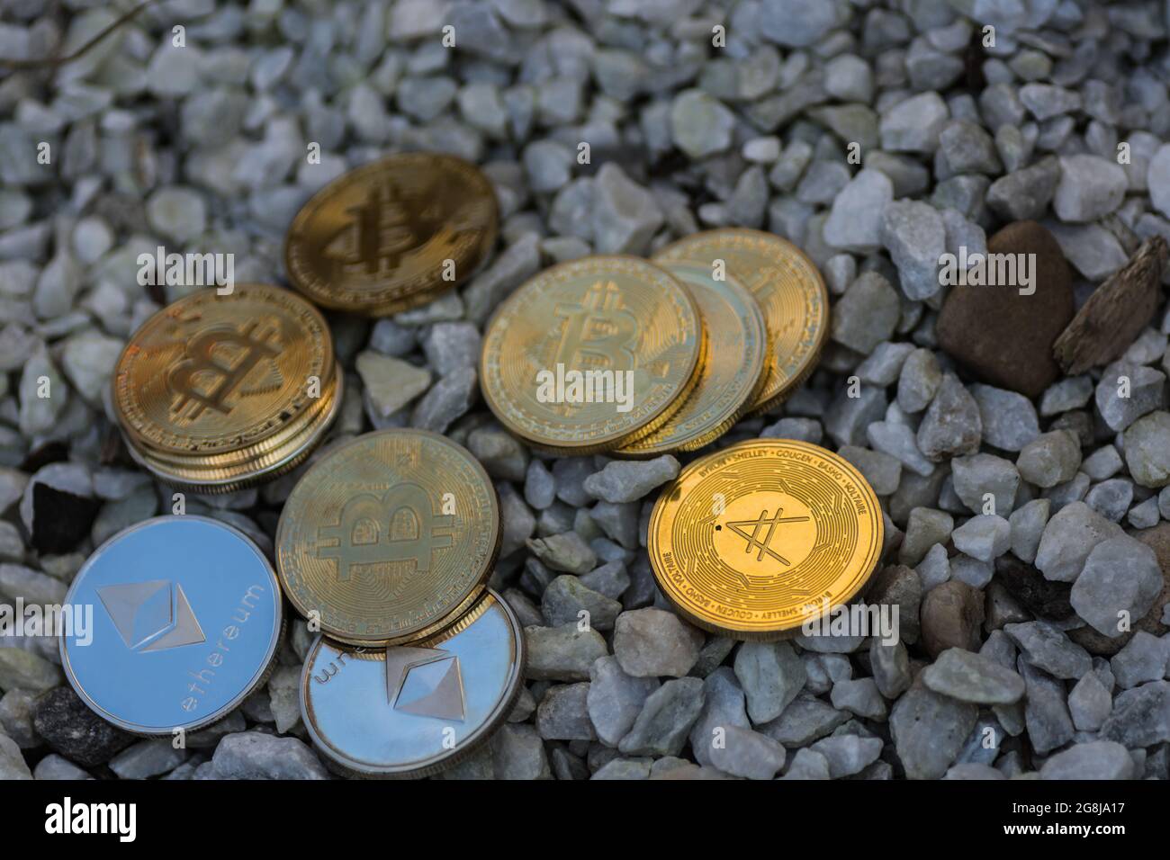 beaucoup d'or brillant et de pièces d'argent bitcoin éther et ada de crypto-monnaie couché sur un gravier blanc Banque D'Images