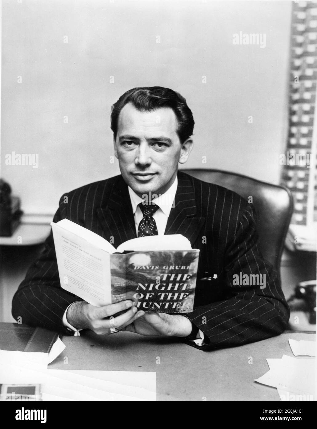 Producteur PAUL GREGORY Portrait tenant une copie du livre publicité pour LA NUIT DE LA HUNTER 1955 réalisateur CHARLES LAUGHTON roman Davis Grubb scénario James Agate cinéaste Stanley Cortez musique Walter Schumann direction artistique Hilyard M. Brown Paul Gregory Productions / United Artists Banque D'Images