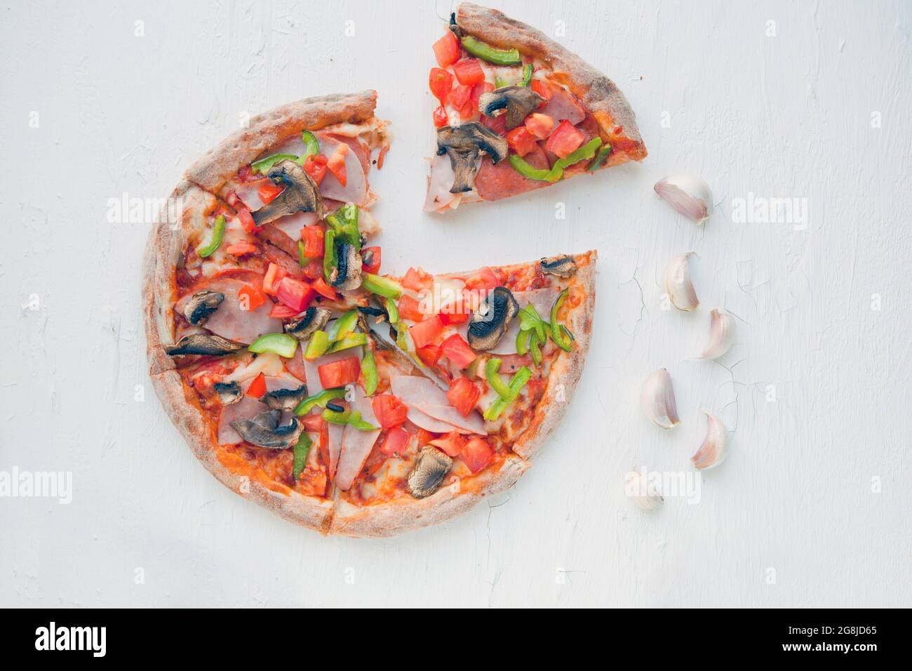 Vue de dessus de la pizza italienne sur une table blanche avec champignons, tomates, olives et fromage. Regardez comme Prosciutto, Capricciosa, PIZZA avec décoration. Photo avec Banque D'Images