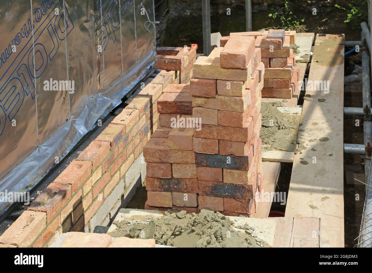 Briques empilées sur un échafaudage pendant la construction du mur extérieur d'un nouveau bungalow à Surrey, Royaume-Uni Banque D'Images