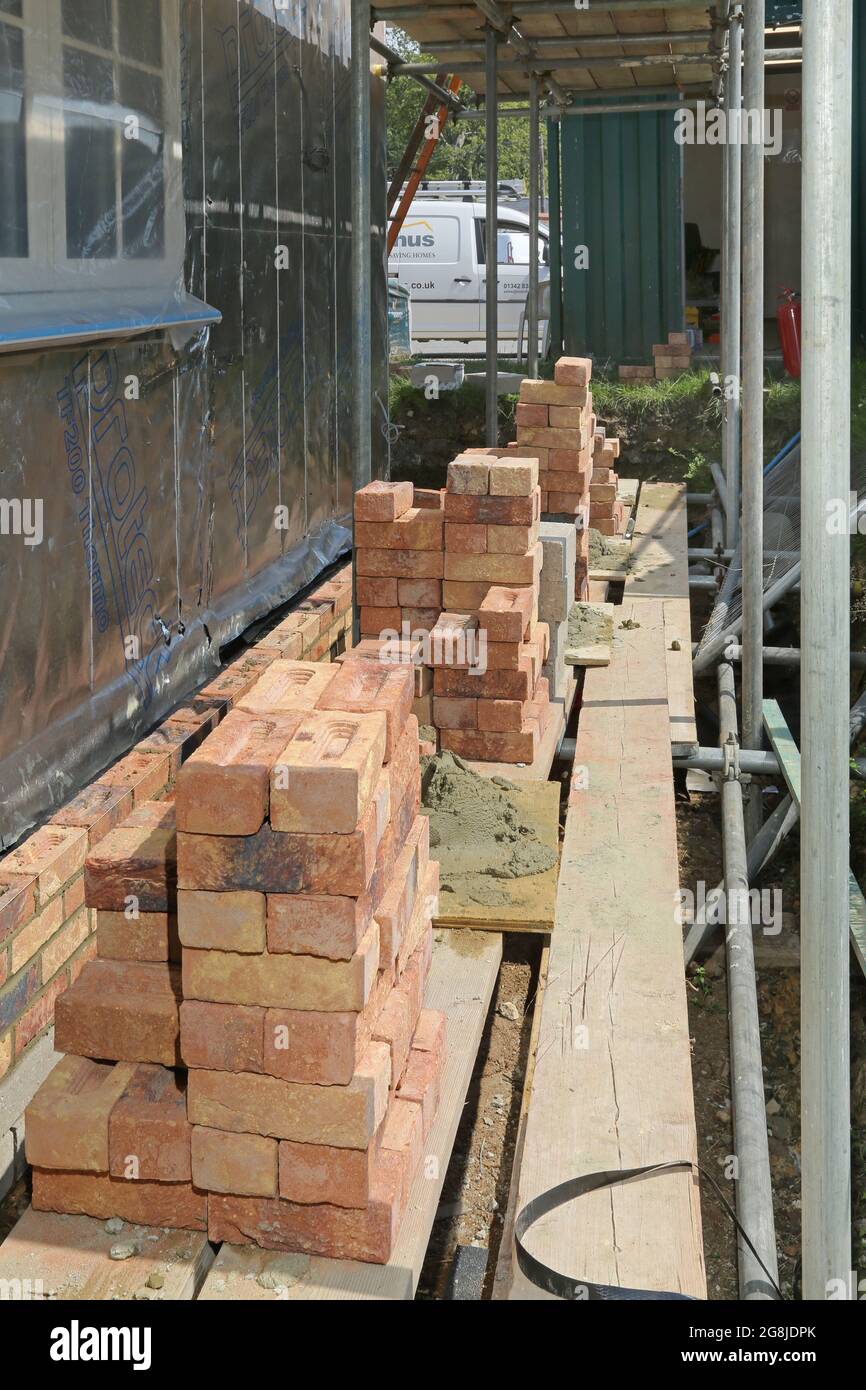 Briques empilées sur un échafaudage pendant la construction du mur extérieur d'un nouveau bungalow à Surrey, Royaume-Uni Banque D'Images