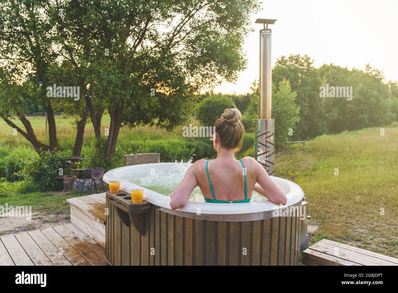 Une femme peut profiter d'un bain à remous extérieur ofuro japonais dans un  environnement romantique. Baignoire idyllique au coucher du soleil Photo  Stock - Alamy