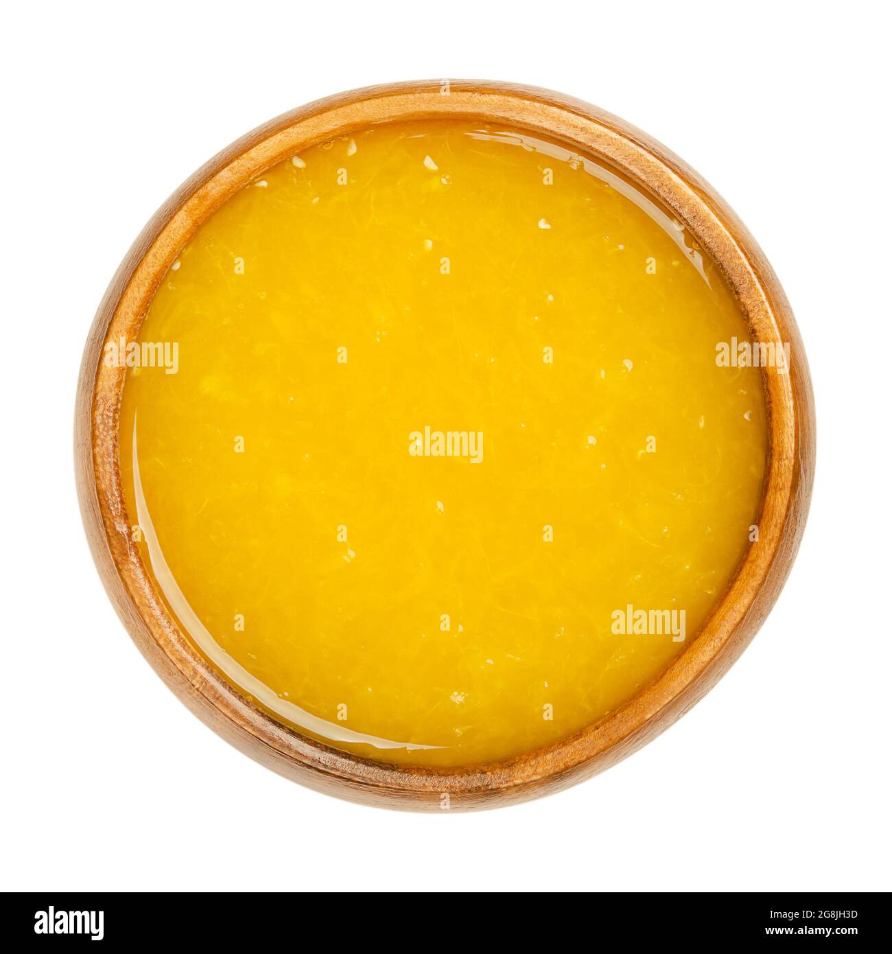 Jus d'orange fraîchement pressé avec pulpe de fruit dans un bol en bois. Jus d'orange fraîchement pressé, un rafraîchissement sucré de couleur jaune intense. Banque D'Images