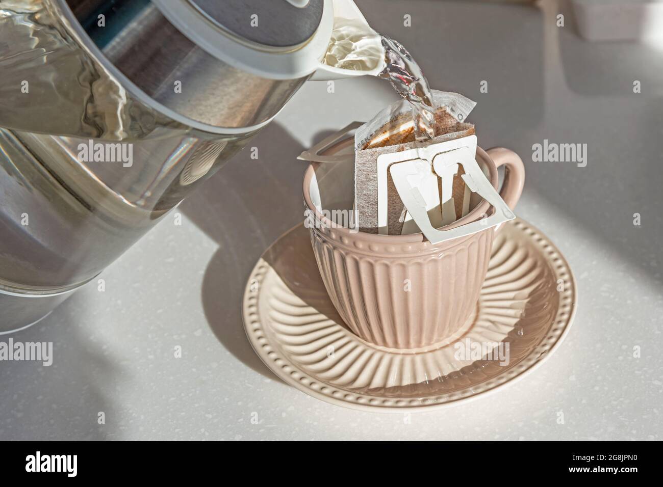 Faire un café avec un sac de café dans une tasse beige sur une table en marbre blanc Banque D'Images