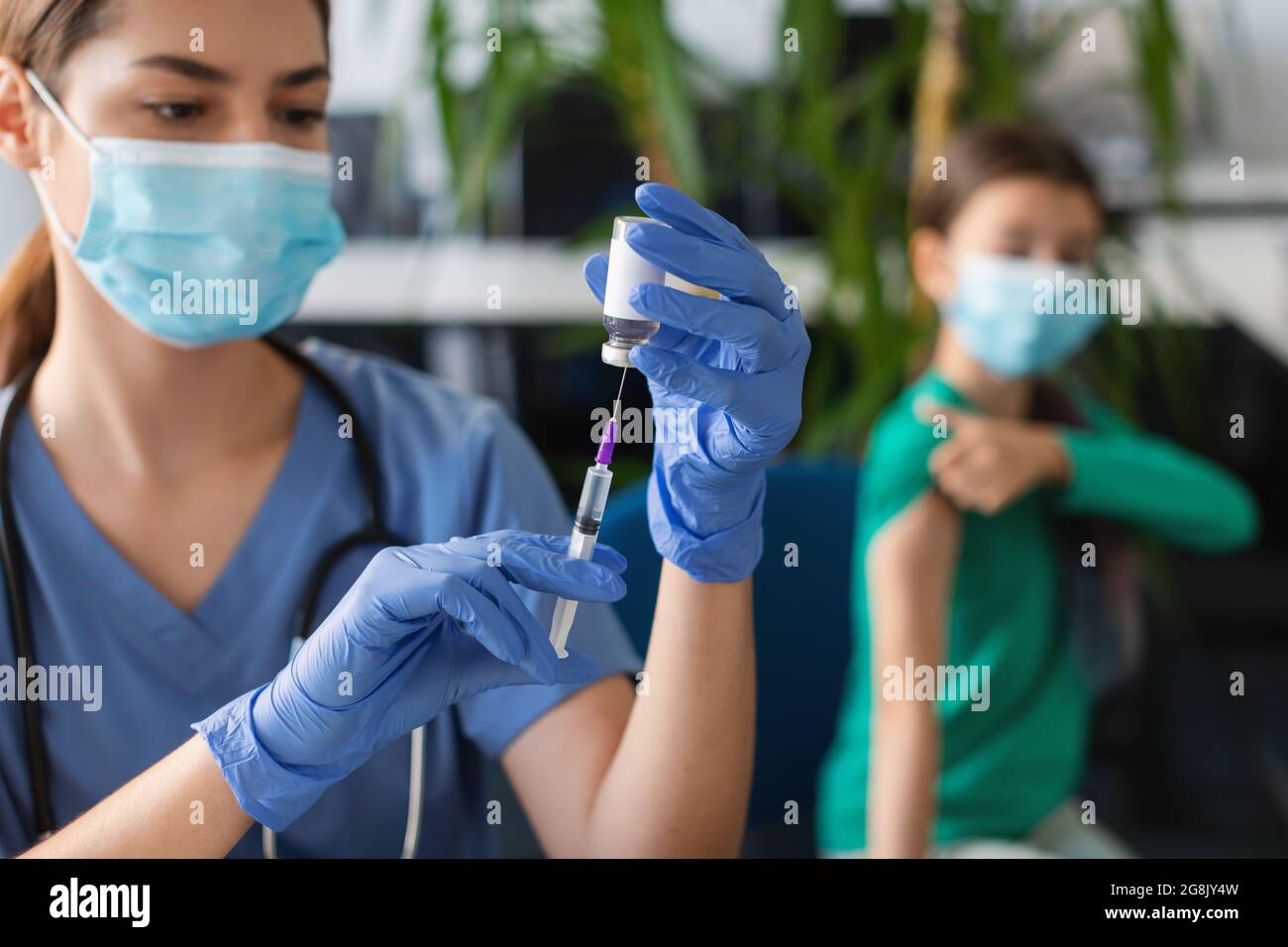 Infirmière avec une seringue prenant la dose du vaccin Covid-19 du flacon Banque D'Images