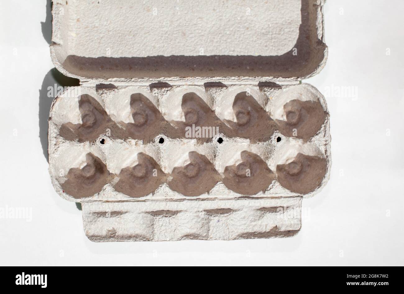 Carton gris à œufs sans œufs sur fond blanc. Boîte en carton à œufs en papier recyclé avec motif abstrait répété Banque D'Images