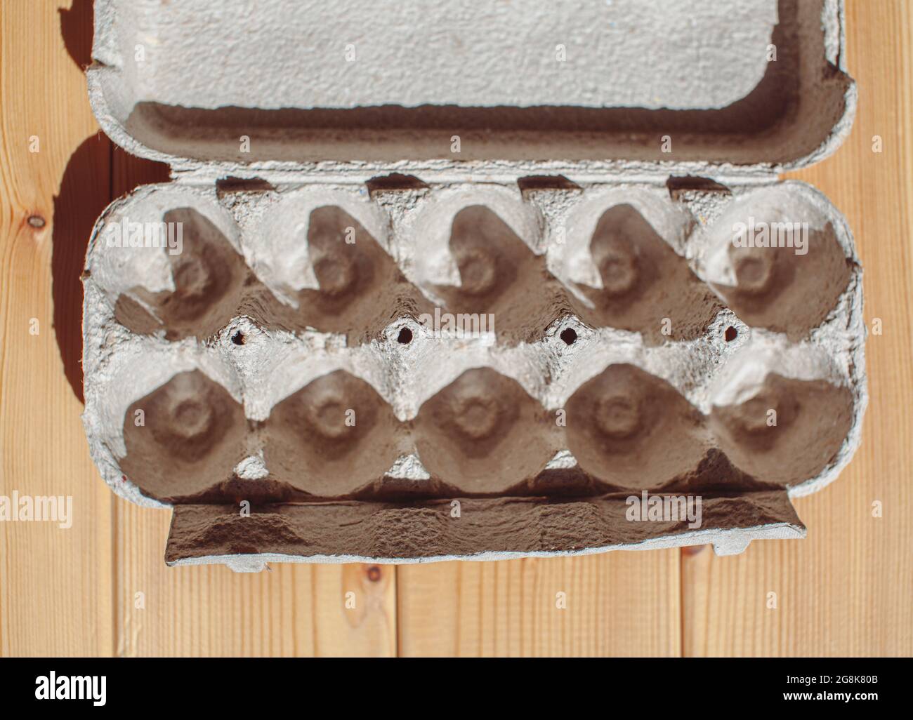 Carton gris à œufs sans œufs sur fond blanc. Boîte en carton à œufs en papier recyclé avec motif abstrait répété Banque D'Images