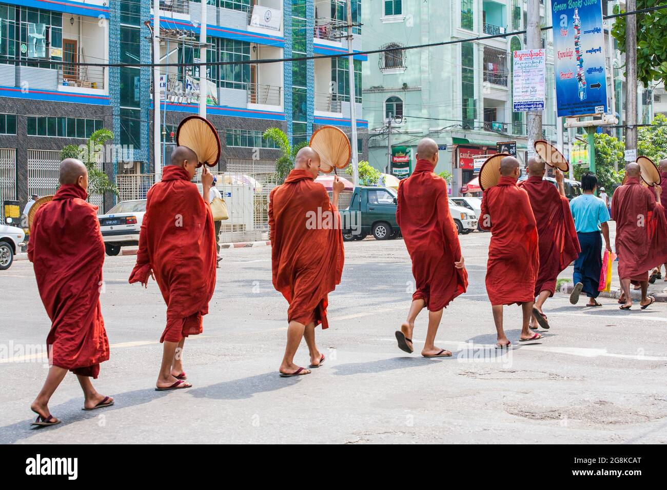 Groupe de Monks bouddhistes birmans portant des robes marron et marron traversant la rue, Yangon, Myanmar Banque D'Images