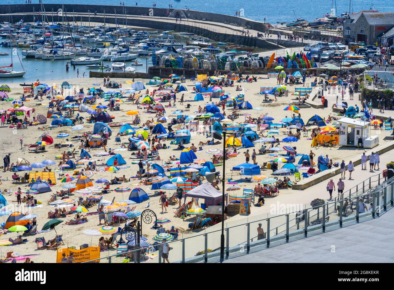 Lyme Regis, Dorset, Royaume-Uni. 21 juillet 2021. Météo au Royaume-Uni: La foule des gens de plage a emballé la plage pittoresque à la station balnéaire de Lyme Regis que les températures ont grimpé vers 30 degrés centigrade encore cet après-midi. Les vacanciers et les amateurs de plage ont connu des températures record tandis que le met Office a prolongé l'avertissement ambre de « chaleur extrême » alors que la vague de chaleur continue jusqu'à la fin de la semaine. Credit: Celia McMahon/Alamy Live News Banque D'Images