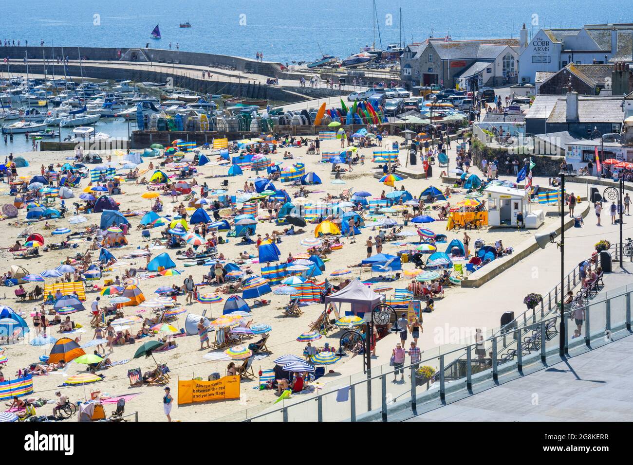 Lyme Regis, Dorset, Royaume-Uni. 21 juillet 2021. Météo au Royaume-Uni: La foule des gens de plage a emballé la plage pittoresque à la station balnéaire de Lyme Regis que les températures ont grimpé vers 30 degrés centigrade encore cet après-midi. Les vacanciers et les amateurs de plage ont connu des températures record tandis que le met Office a prolongé l'avertissement ambre de « chaleur extrême » alors que la vague de chaleur continue jusqu'à la fin de la semaine. Credit: Celia McMahon/Alamy Live News Banque D'Images