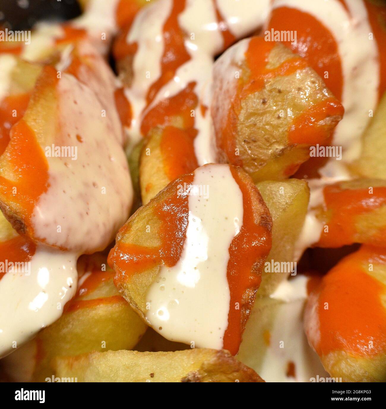 Détail macro des pommes de terre bravas, frites avec la peau, la mayonnaise et les sauces épicées aux tomates. Plat typique et traditionnel de la gastronomie espagnole. La Rioja, SP Banque D'Images
