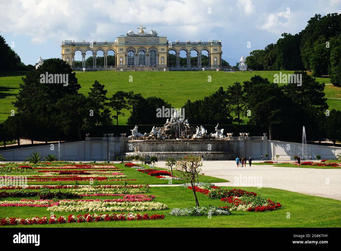 Wien, Österreich - Blick vom Schloss Schönbrunn in Richtung Neptunbrunnen und Gloriette über herrliche Blumen und Parkanlagen Banque D'Images