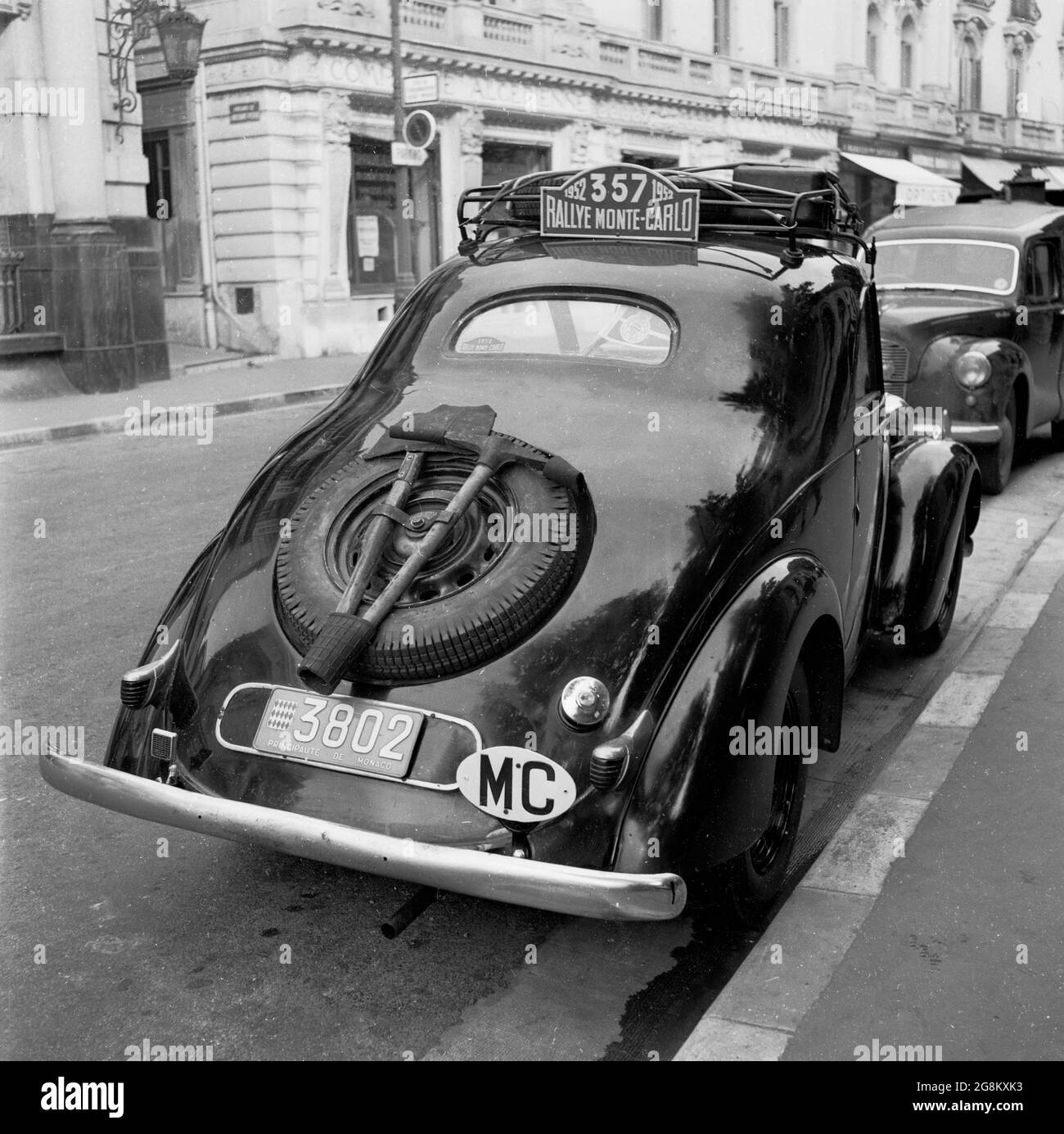 Années 1950, historique, Monaco. Garée dans une rue latérale de Monte-Carlo, une voiture moncao enregistrée, prenant part au rallye de Monte Carlo. Le numéro 357 se trouve sur la galerie de toit. Notez le pickax et la pelle fixés à la roue de secours à l'arrière en pente de la voiture. Banque D'Images