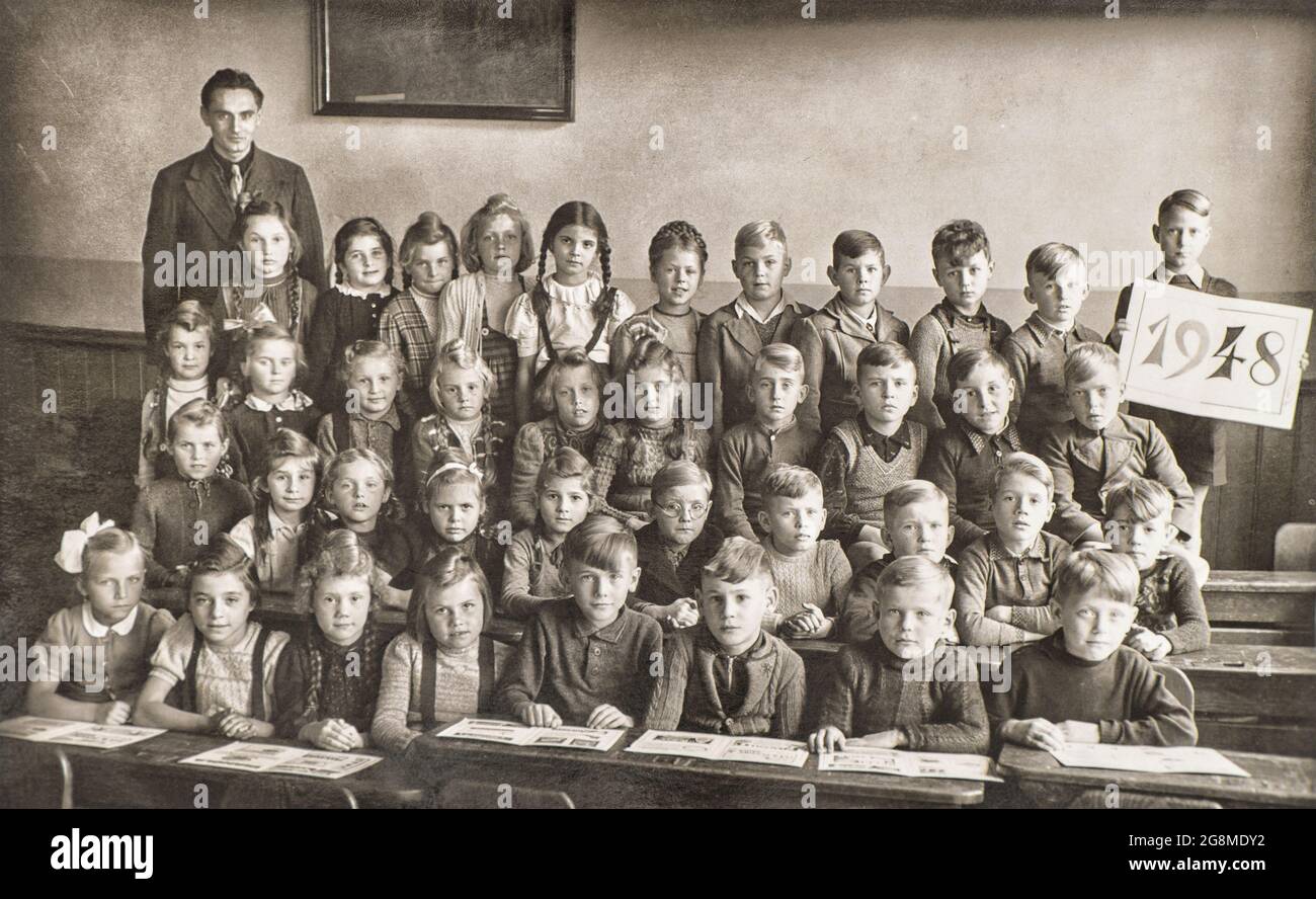 Enfants et enseignant dans la salle de classe. Photo rétro des camarades de  classe à l'école. Photo d'époque avec grain de film original à partir de ca  1948 Photo Stock - Alamy