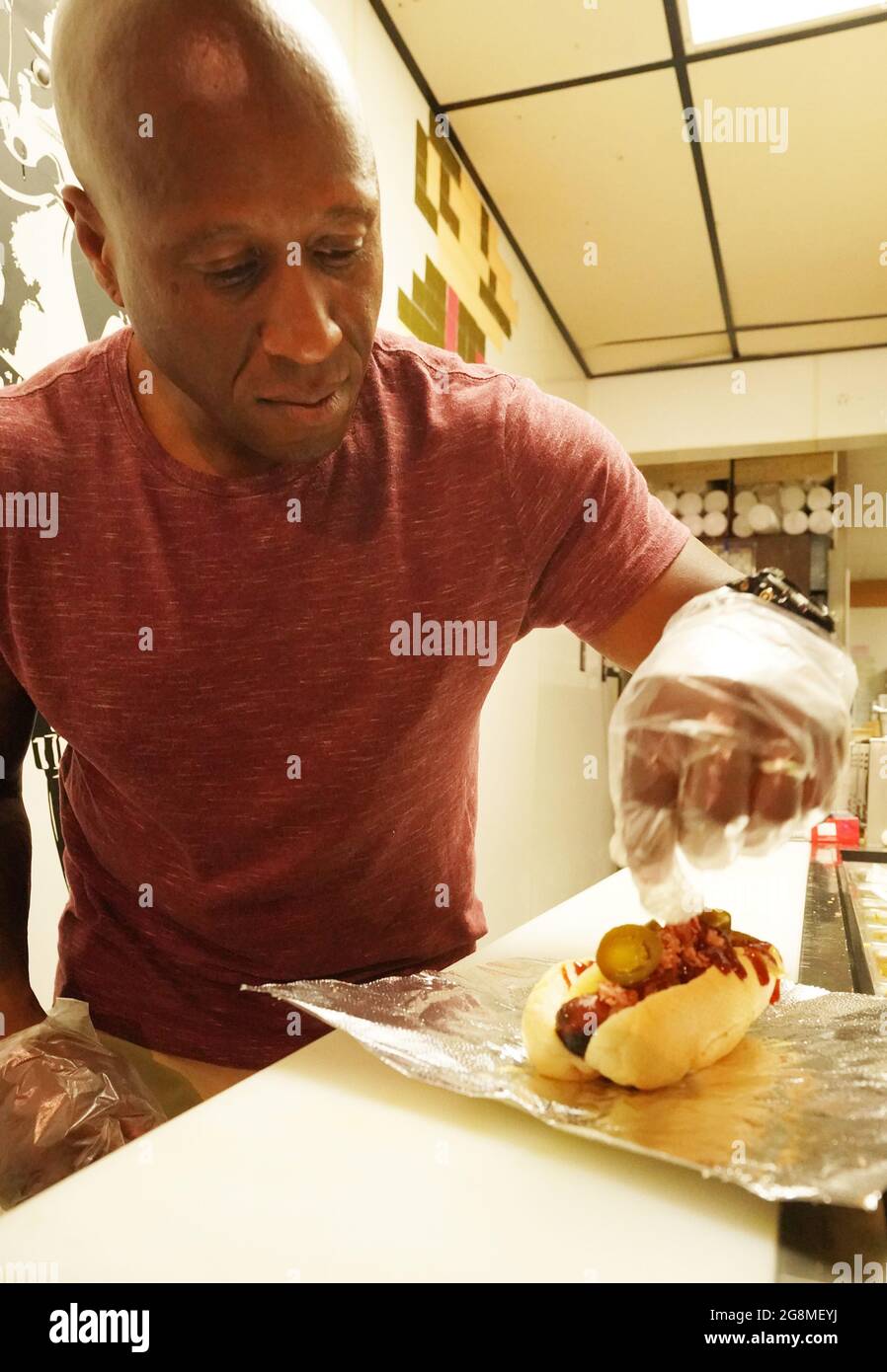 St. Louis, États-Unis. 21 juillet 2021. Steve Ewing, le chanteur principal du groupe The Enge basé à St. Louis, habille un hot dogs lors de la Journée nationale des hot dogs à Steve's Hot Dogs à St. Louis le mercredi 21 juillet 2021. Photo par Bill Greenblatt/UPI crédit: UPI/Alay Live News Banque D'Images