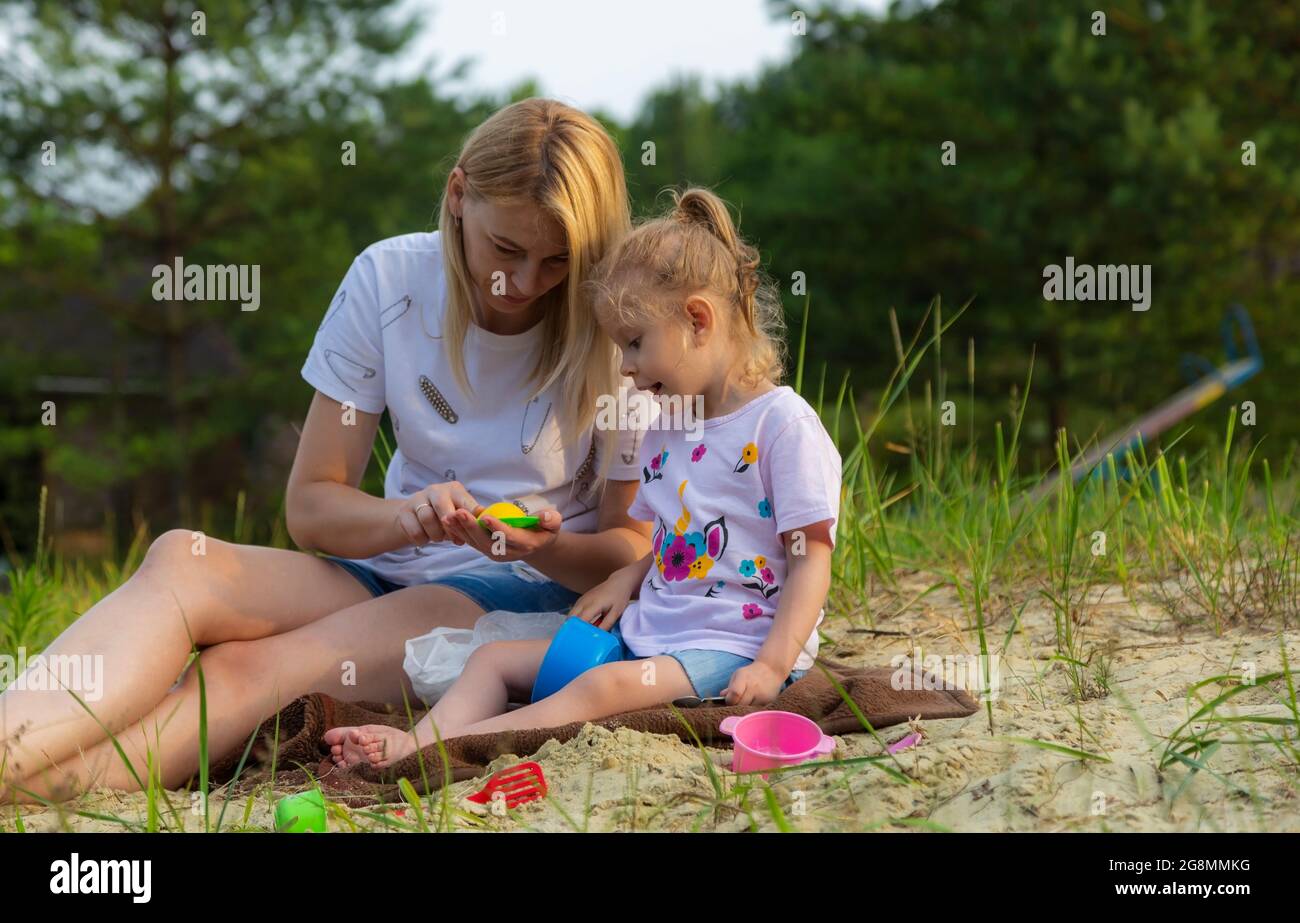 Mere Avec Bebe Jouant Avec Le Sable Sur La Plage Sculptant Des Gateaux De Paques La Fille A 4 Ans Jeux Pour Enfants Divertissements Photo Stock Alamy