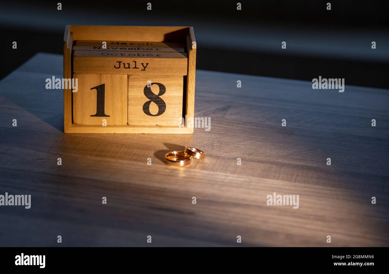 Juillet 18 sur des blocs de bois. Sur le fond des anneaux de mariage. Vacances, calendrier en bois, jours et mois de l'année. Banque D'Images