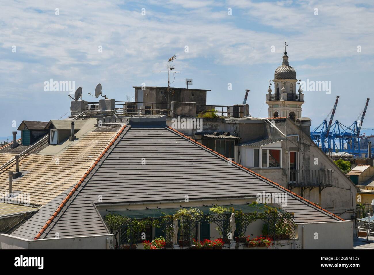 Vue sur les toits de la ville côtière avec balcons, clocher et grues dans le port en arrière-plan, Gênes, Ligurie, Italie Banque D'Images