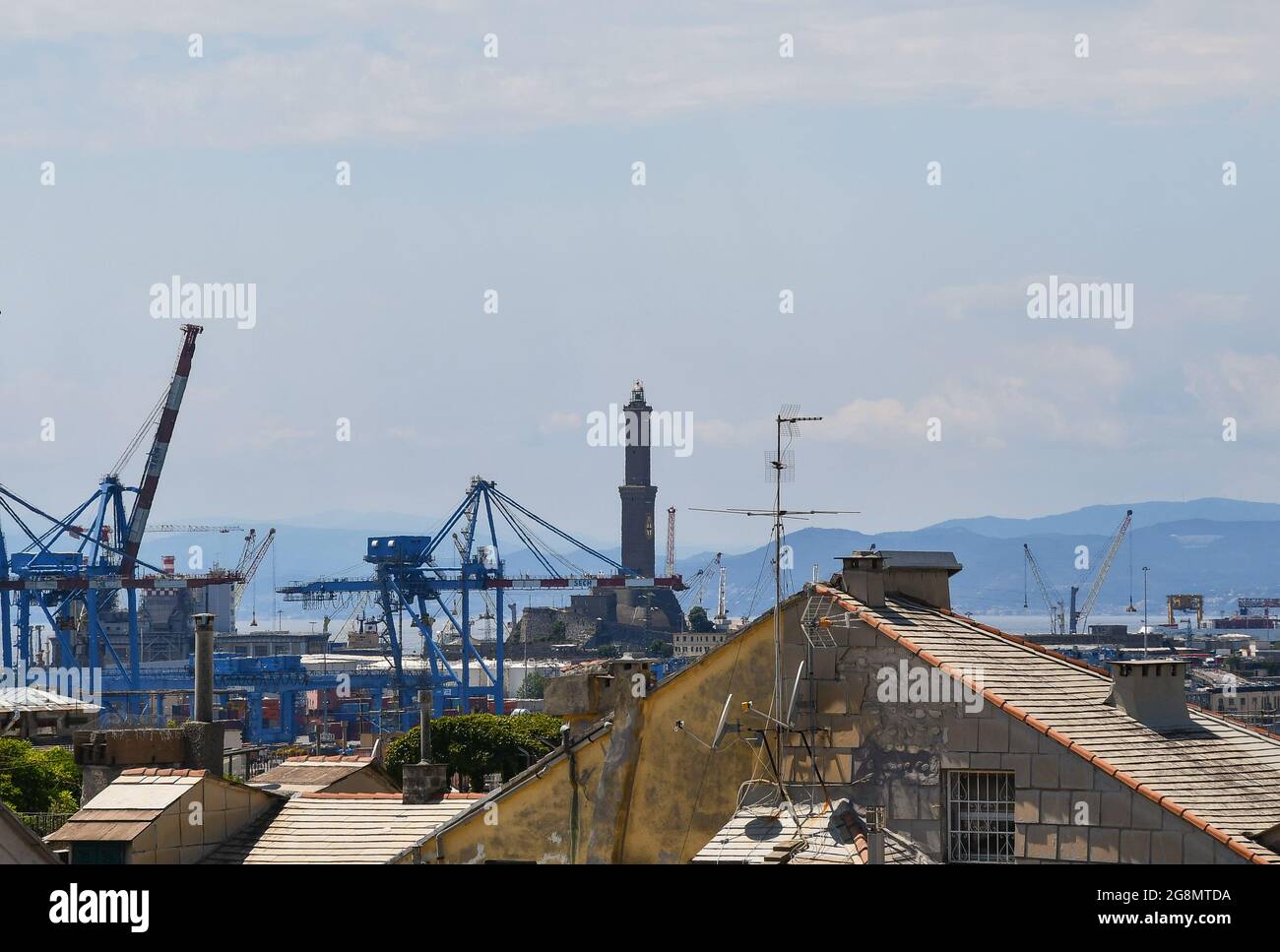 Vue sur les toits avec grues et le phare de Lanterna, symbole de la ville côtière de Gênes, Ligurie, Italie Banque D'Images