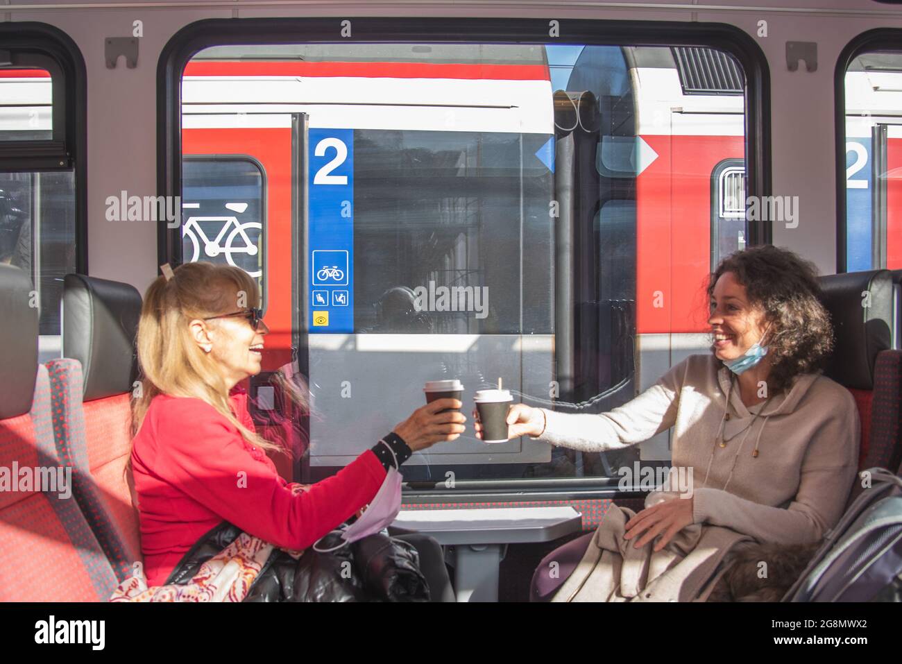 Des femmes heureuses voyageant en train pour faire un toast avec un café et s'amuser. Banque D'Images