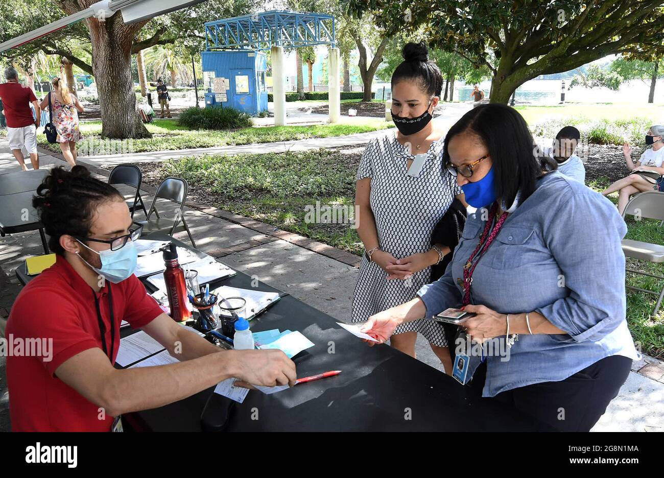 Orlando, États-Unis. 21 juillet 2021. Annie Velez (à gauche) et Lisa Wilson s'inscrivent pour recevoir une dose du vaccin Pfizer sur un site mobile de vaccination COVID-19.les nouveaux cas de COVID-19 en Floride ont doublé au cours de la dernière semaine, la plupart des cas étant identifiés comme étant la variante delta hautement contagieuse qui est en hausse dans tout le pays. Crédit : SOPA Images Limited/Alamy Live News Banque D'Images