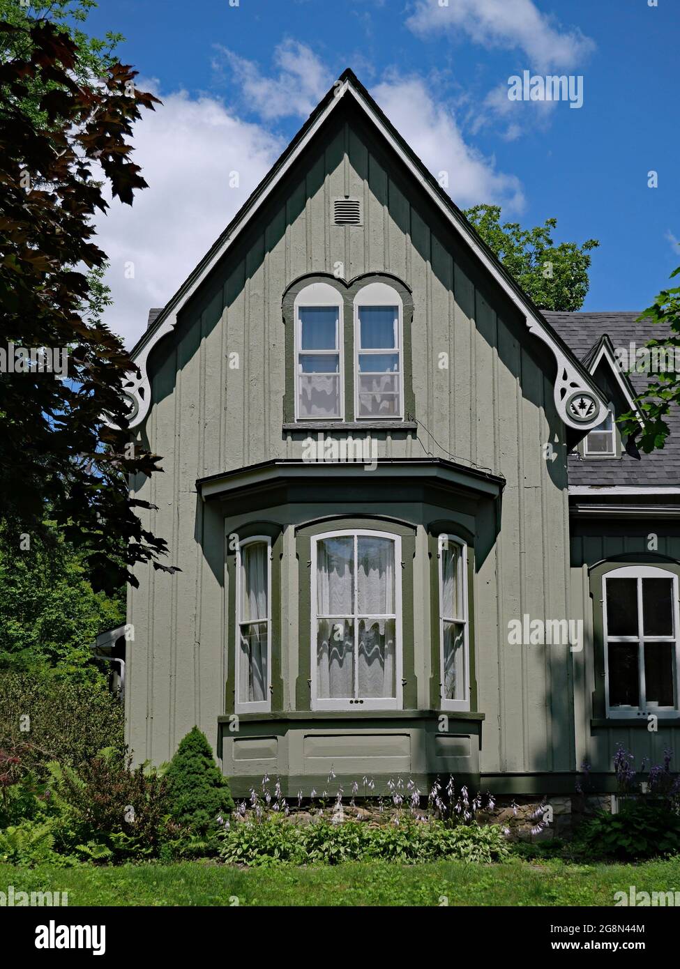 Ancienne maison de style gothique américain avec baie vitrée, peinte en vert pâle Banque D'Images