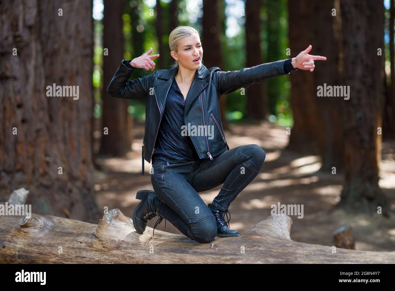 Jeune femme sur une grande bûche de séquoias tombés dans redwood grove Banque D'Images