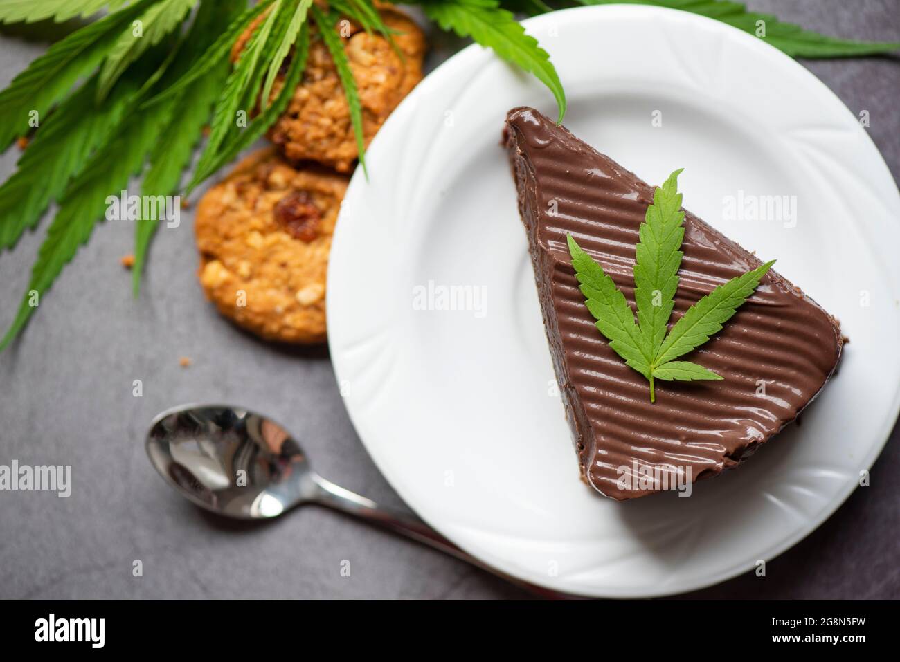 Gateau Au Chocolat Et Biscuits Avec Feuille De Cannabis La Plante De Feuilles De Marijuana Sur La Plaque Blanche Sur La Table En Bois Cannabis Alimentaire Nature Herbe Concept Photo Stock