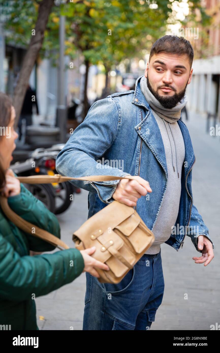 Un voleur de rue vole le sac à main de la femme Banque D'Images