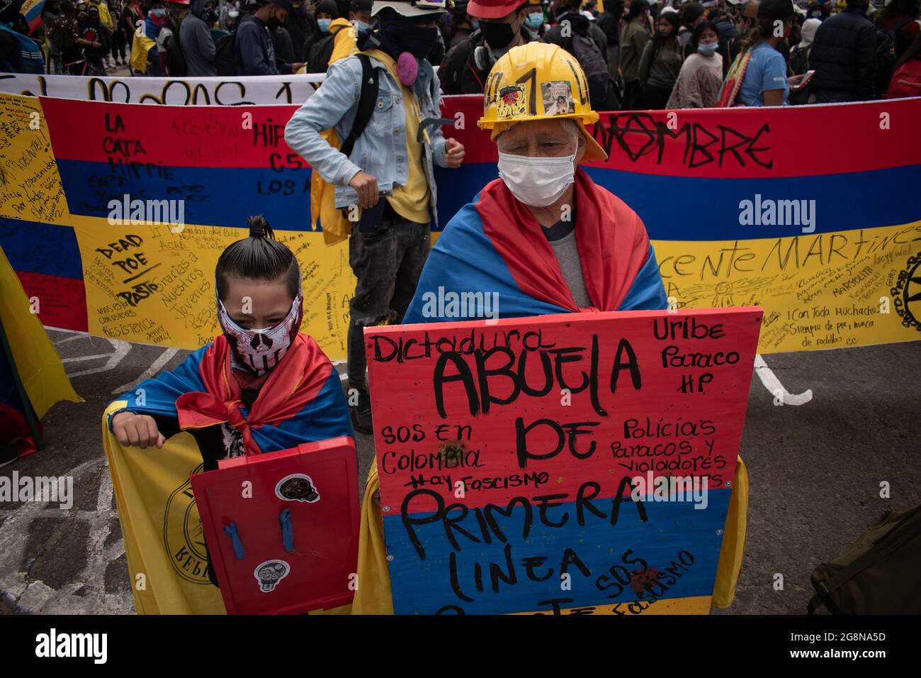 Une femme aînée et un enfant portent des boucliers pour soutenir la ligne de front lors d'une nouvelle journée de manifestations anti-gouvernementales lors de la célébration de l'indépendance de la Colombie par rapport à l'espagne en 211, manifestations soulevées dans des affrontements dans diverses villes après l'intervention de la police anti-émeute colombienne ESMAD, à Bogota, Colombie le 20 juillet, 2021. Banque D'Images