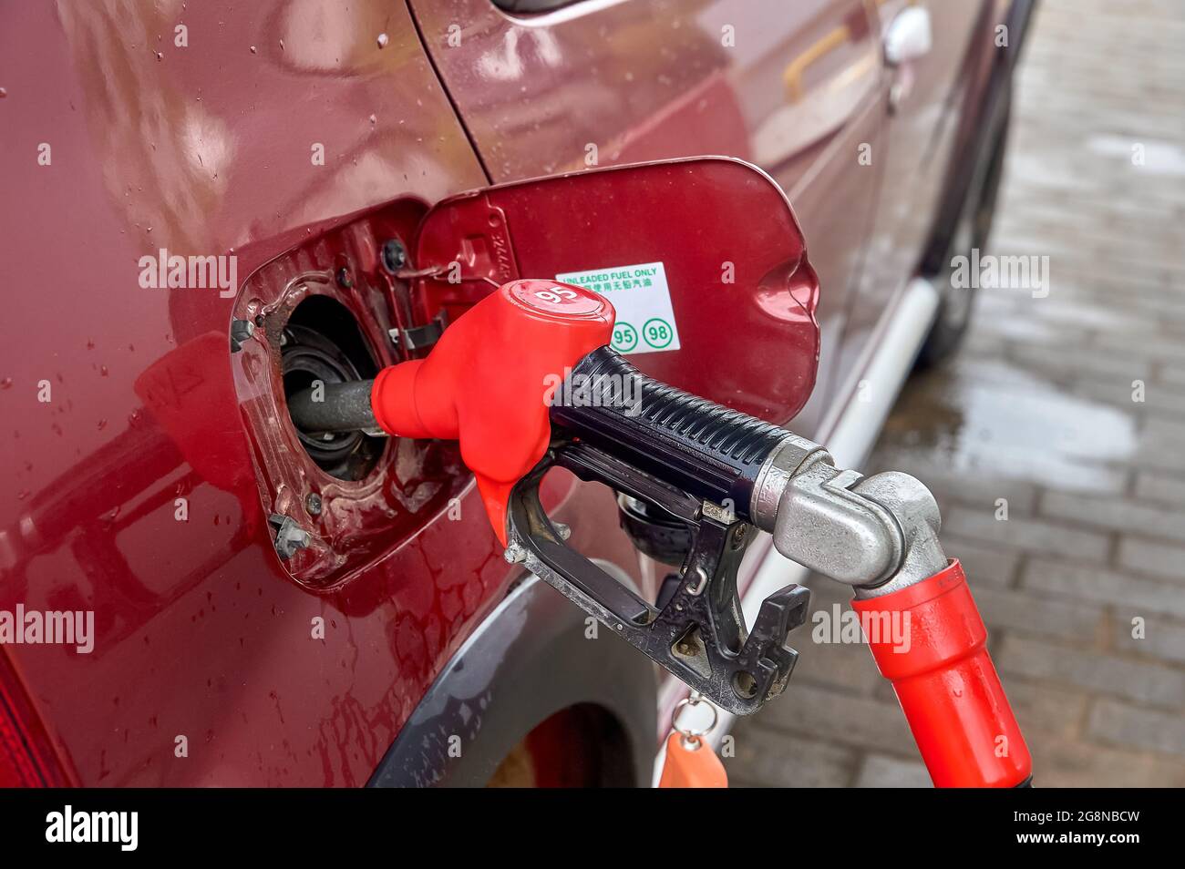 le pistolet est inséré dans le réservoir de gaz de la voiture Banque D'Images