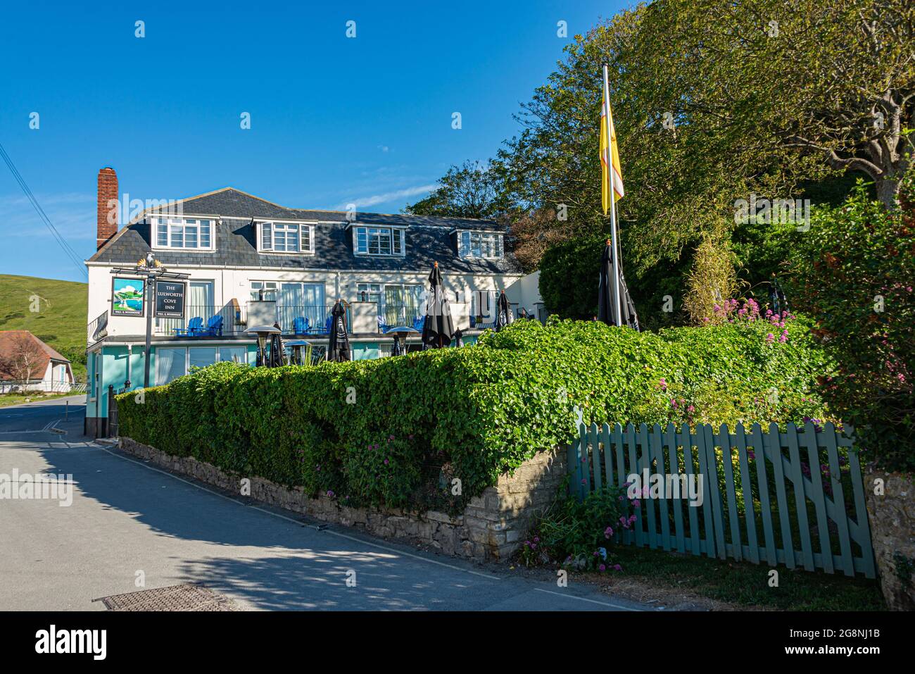 Lulworth Cove Inn et le café en plein air arrière le matin d'un été chaud avec un ciel bleu et aucune personne. West Lulworth, Wareham, Dorset, Angleterre Banque D'Images