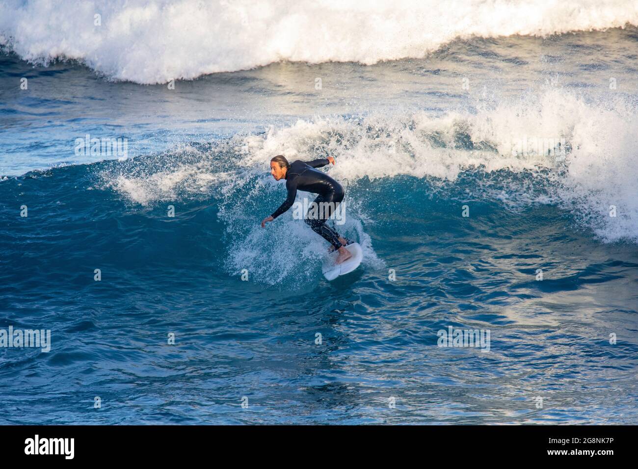 Surfeur masculin dans une combinaison surfant sur la côte d'Avalon Beach à Sydney, Nouvelle-Galles du Sud, Australie Banque D'Images
