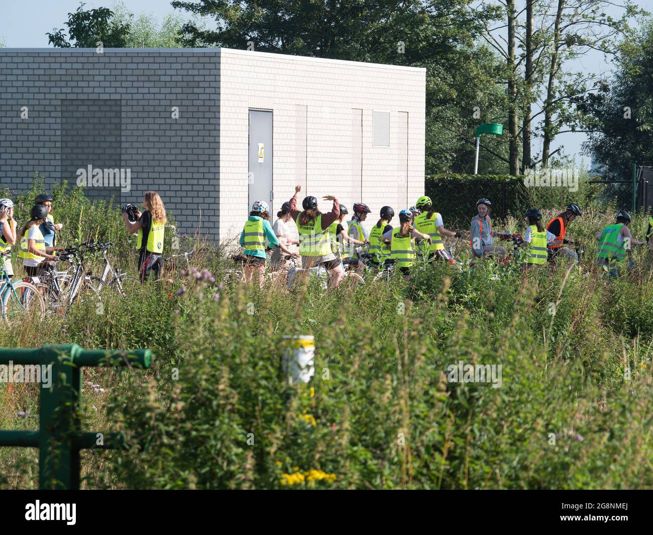 Sint Gillis Waas, Belgique, 11 juillet 2021, Groupe de scouts locaux portant des gilets fluorescents jaunes se préparer à une balade en vélo Banque D'Images