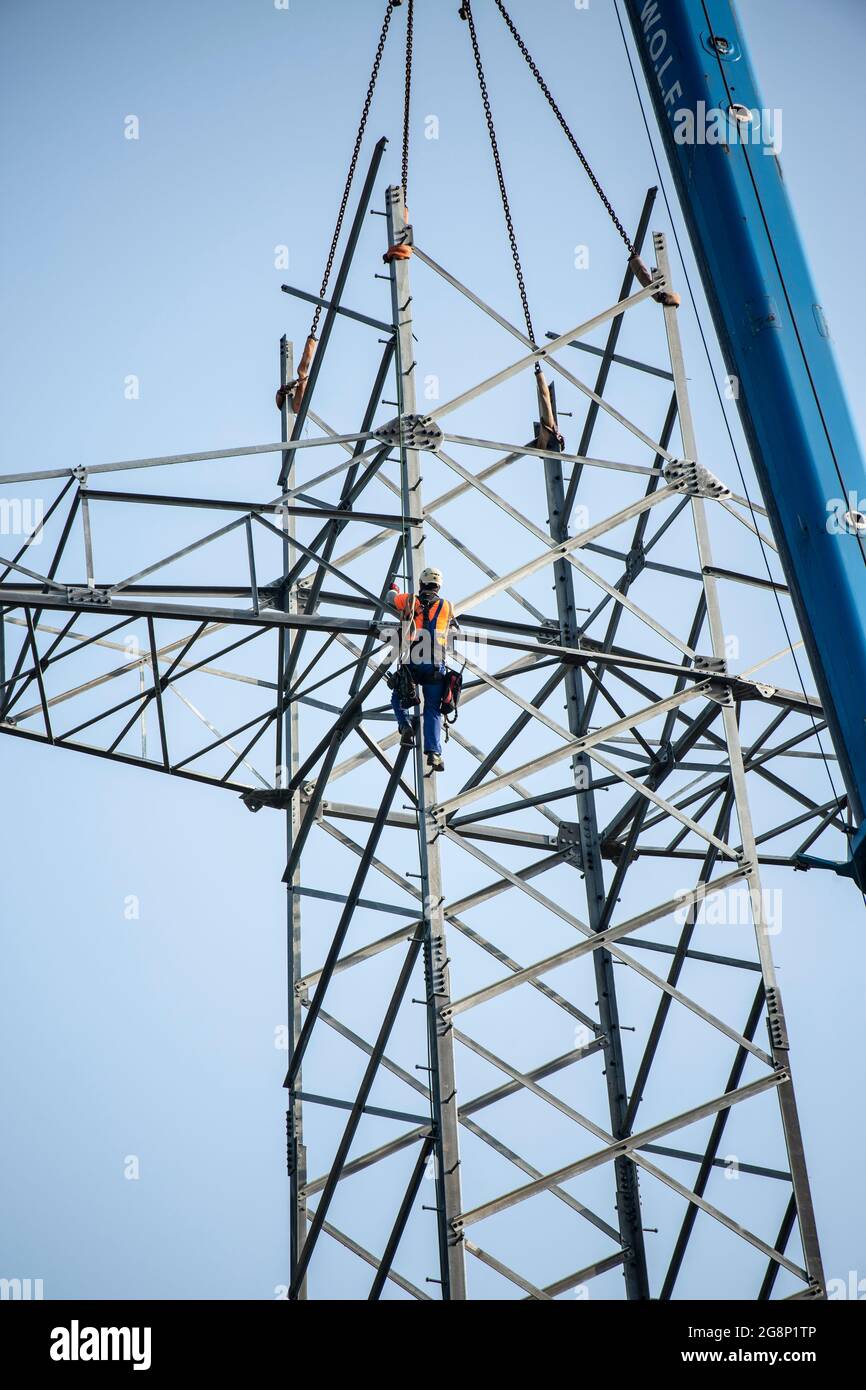 Auf einem Feld zwischen Kaarst und Düsseldorf bauen Mitarbeiter der Firma  SPIE Leitungsbau einen Elektrizitätsmast auf. Wie Playmobil-Männchen sehen  d Photo Stock - Alamy