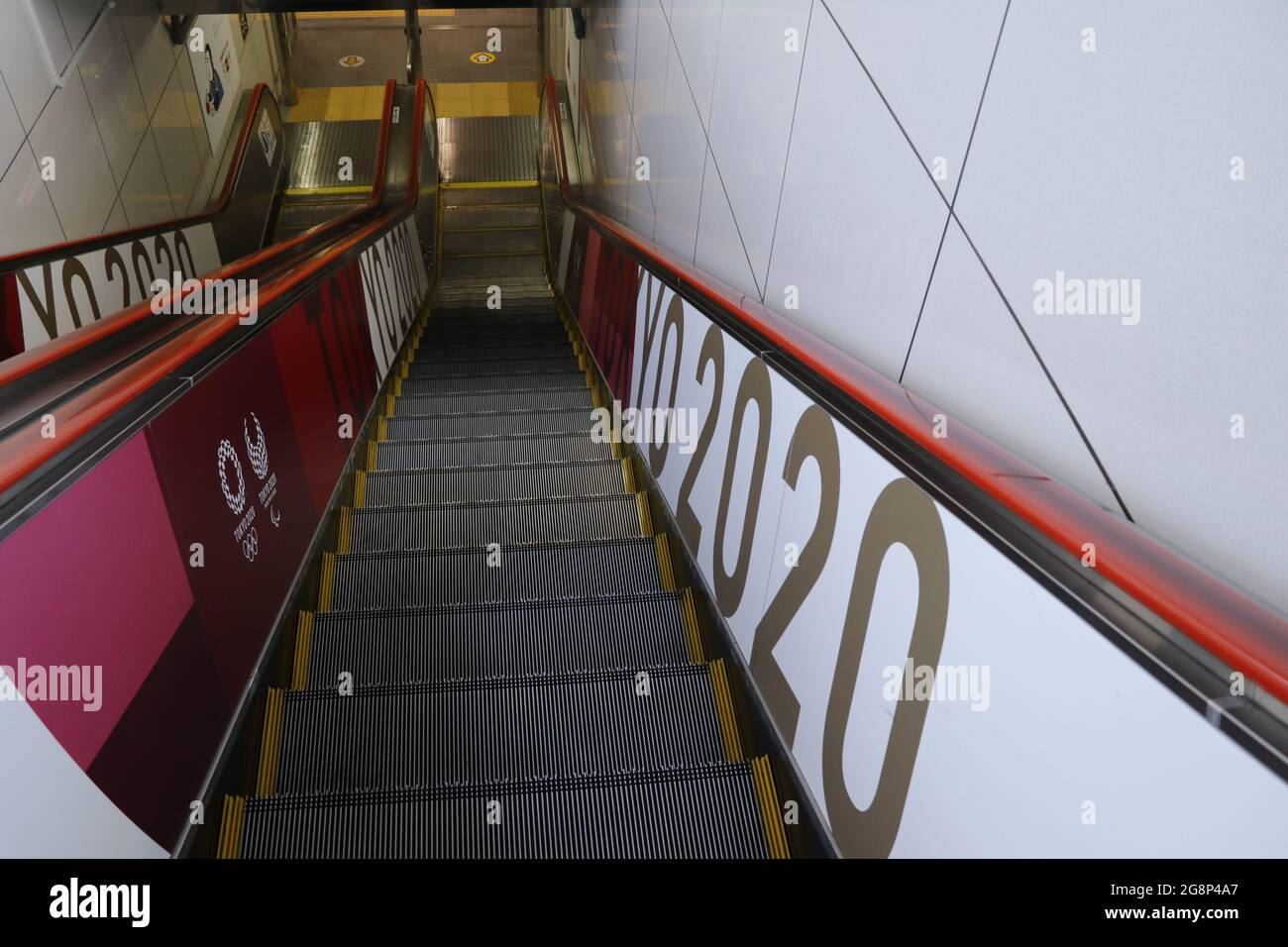 Escalier roulant avec le logo des Jeux Olympiques de Tokyo 2020 à la gare proche du Stade National. Banque D'Images