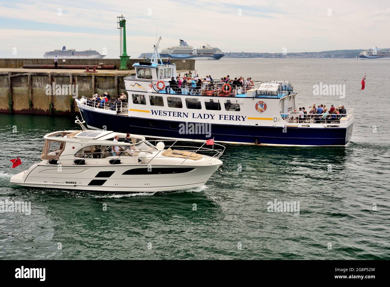 WESTERN Lady Ferry le coentrepreneur de Dart passe devant une cabine de croisière à son entrée dans le port de Torquay, tandis que les bateaux de croisière sont ancrés en arrière-plan. Banque D'Images